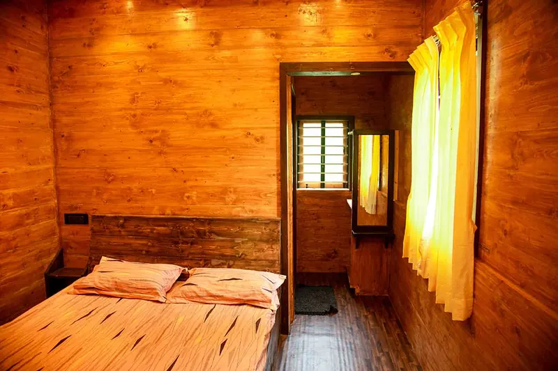Wood-panelled guest room at Jungle Valley Farms with a double bed and ensuite bathroom