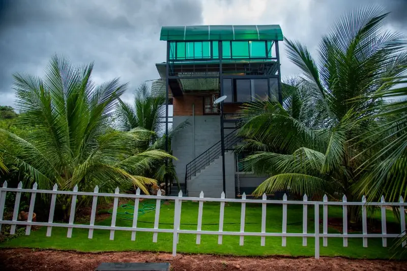 The tower room among coconut palms behind the white fence