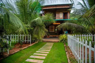 The wooden farmhouse seen from the lawn, stepping-stone path leading to the porch