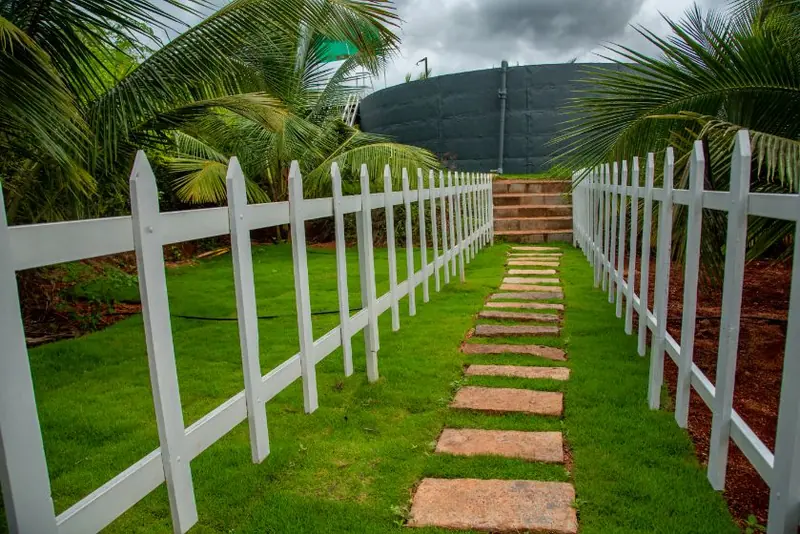 Lawn walkway lined with a white picket fence