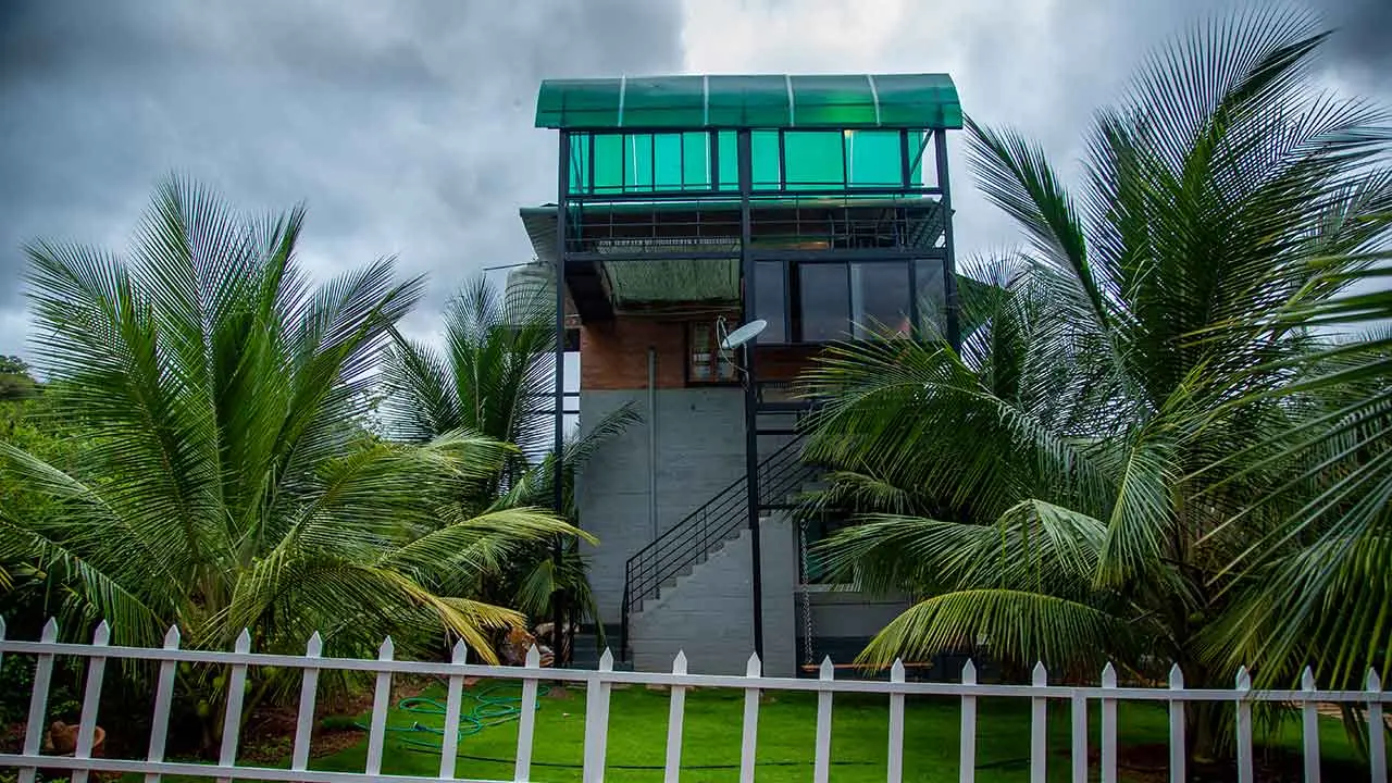 The farm tower block at Jungle Valley Farms with its green canopy roof behind a white picket fence