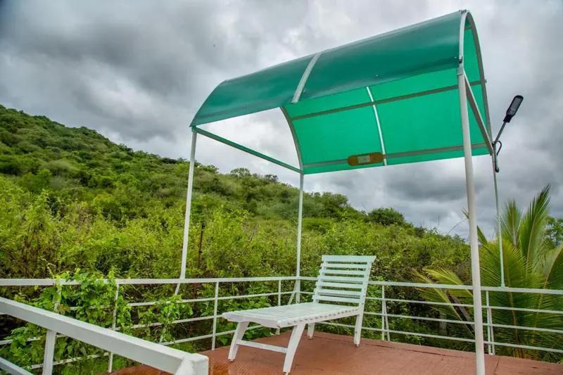 Canopy sit-out with a bench overlooking the forested hills