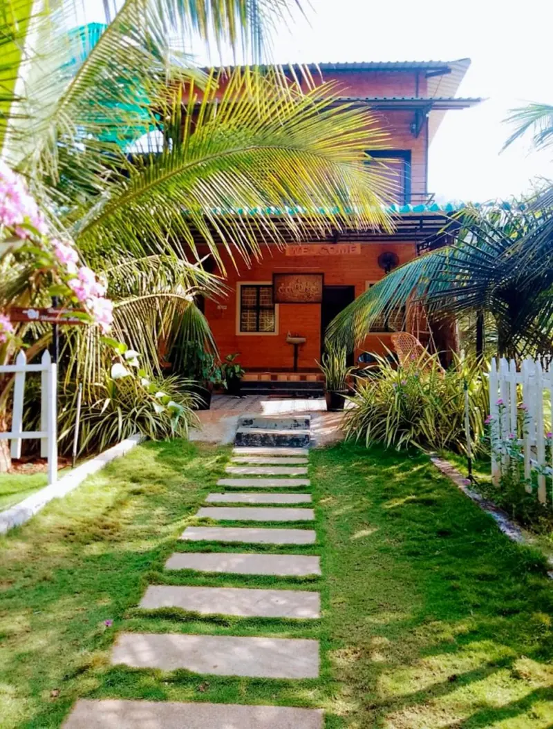 Path of stepping stones through the lawn to the farmhouse porch